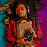 Man with afro and headphones enjoying retro music surrounded by vintage items.